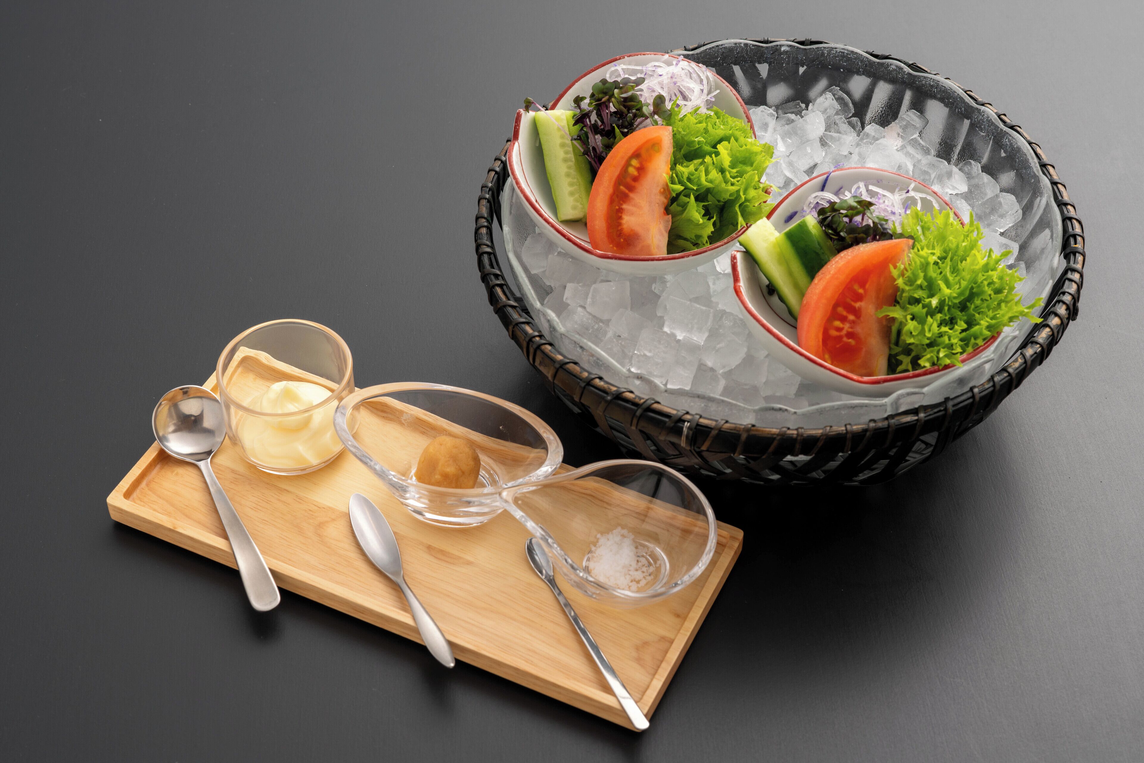 A tray with a bowl of ice, a glass of water, and a small bowl of salt.