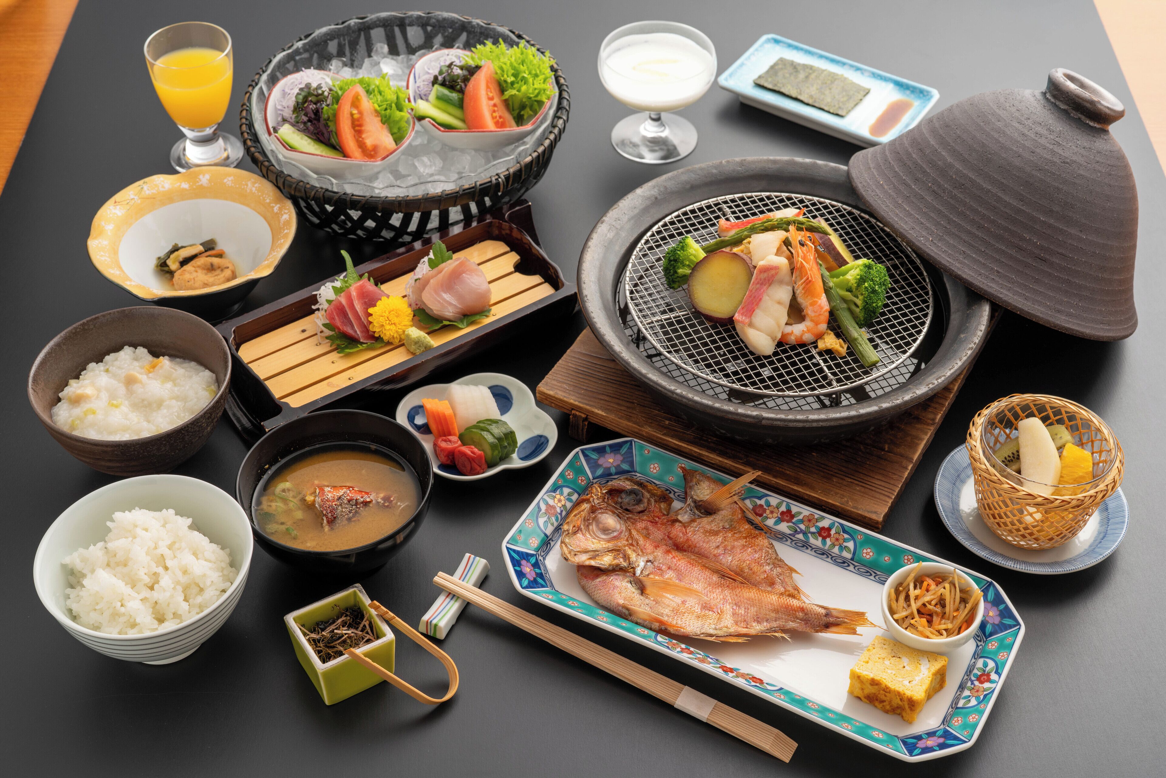 A table set with various dishes including rice, soup, fish, and vegetables.