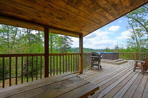 A wooden deck with a grill and seating area, overlooking a forested landscape. - Above the Rest: 🏔 View•Hot Tub•Nearby Attractions (Sevierville)