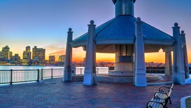 A gazebo with a tiled roof and columns, overlooking a waterfront with a city skyline in the background. - Beautiful 4BD/2BA Gem! Near airport, city, subway. (Boston)