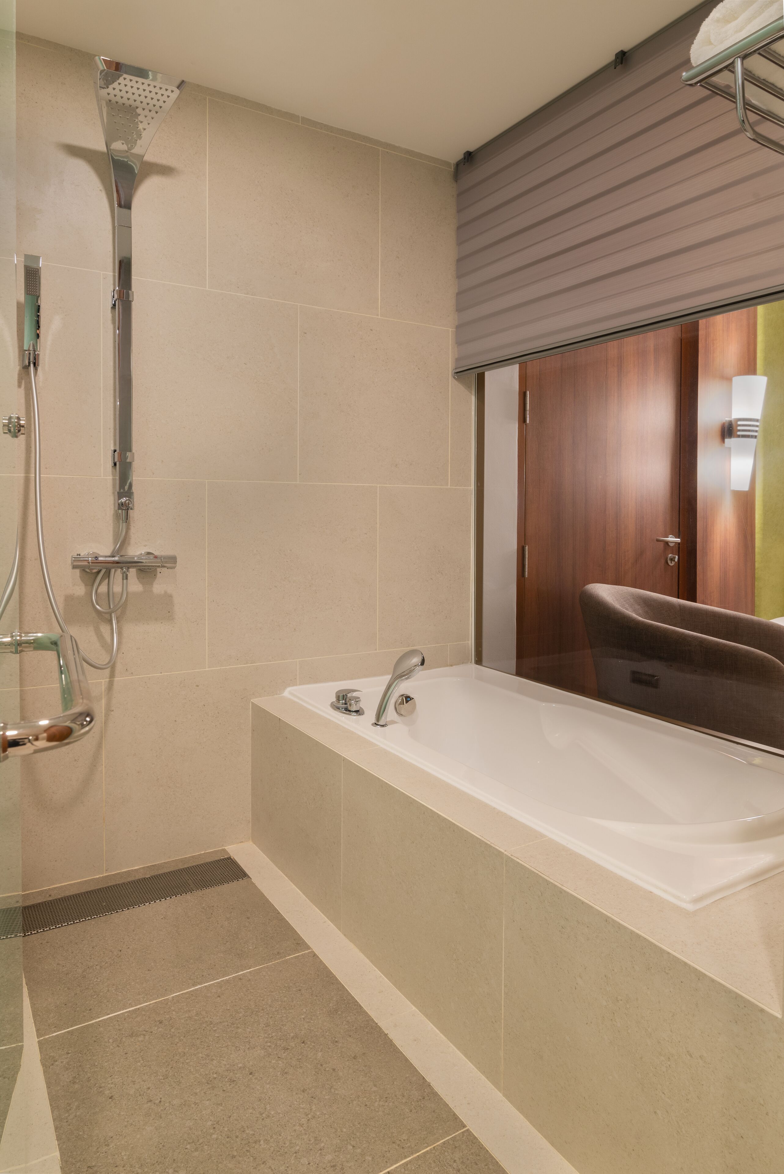 A modern bathroom with a bathtub, shower, and a vanity with a mirror.