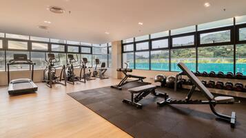 Ein Fitnessraum mit Cardiogeräten, Krafttrainingsgeräten und Kurzhanteln.