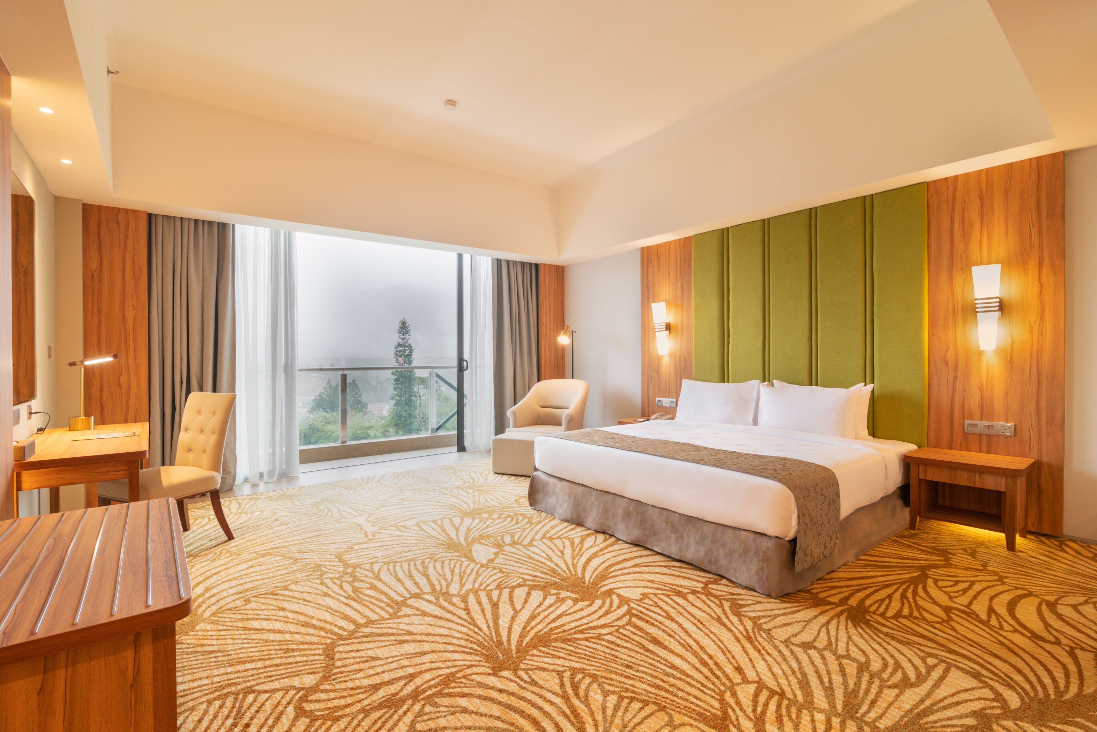 Habitación de hotel con una cama grande, un escritorio, una silla y vistas al exterior.