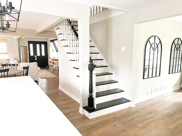 A staircase with black balusters and white walls, leading to a second floor.