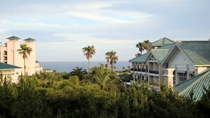 Un resort con varias edificaciones, palmeras y vista al océano.