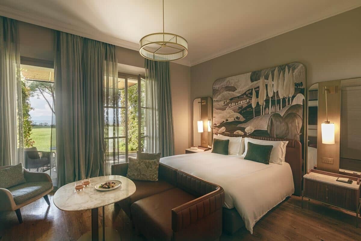 Ett hotellrum med en stor säng, en sittgrupp med ett bord och utsikt över omgivningarna.