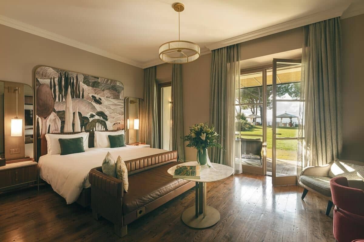 Ett välutrustat hotellrum med en stor säng, en sittgrupp, ett matbord och utsikt över omgivningarna.
