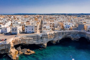 Explore a charming coastal town with a historic stone bridge connecting the mainland to a scenic outcrop.