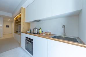 Enjoy cooking in this well-lit kitchen with an oven and stainless steel sink.