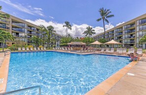 A hotel with a swimming pool, palm trees, and a clear sky. - Maui Ocean + Jeep (Kihei)