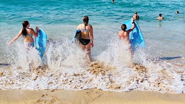 A beach scene with people entering the water, some with surfboards. - 2 Bedroom Ocean Jeep  (Kihei)
