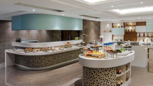 Una cucina moderna con isola a forma di ferro di cavallo, dotata di diversi alimenti ed elettrodomestici.