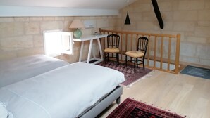 A bedroom with a bed, a desk, two chairs, a lamp, and a window. - Maison au Cœur de Saint-emilion (Saint-Émilion)