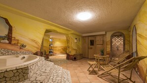 A spa area with a stone-tiled jacuzzi, wooden lounge chairs, and a checkered wall design. - Hotel Gabl by Alpeffect Hotels (Sankt Anton am Arlberg)