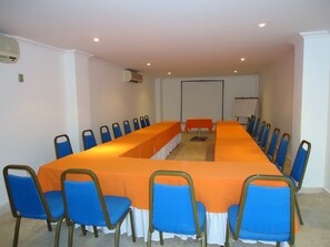 A conference room with a long table, blue chairs, and a whiteboard.