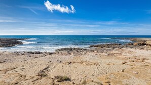 Una spiaggia con un terreno roccioso e l'oceano.