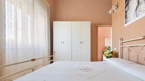 A bedroom with a bed, a wardrobe, and a painting on the wall. - 2038 Villetta Gloria (Alliste)