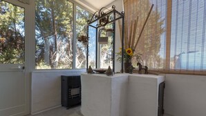 Une pièce dotée d’une grande fenêtre, d’un radiateur et d’une petite table ornée d’objets décoratifs.
