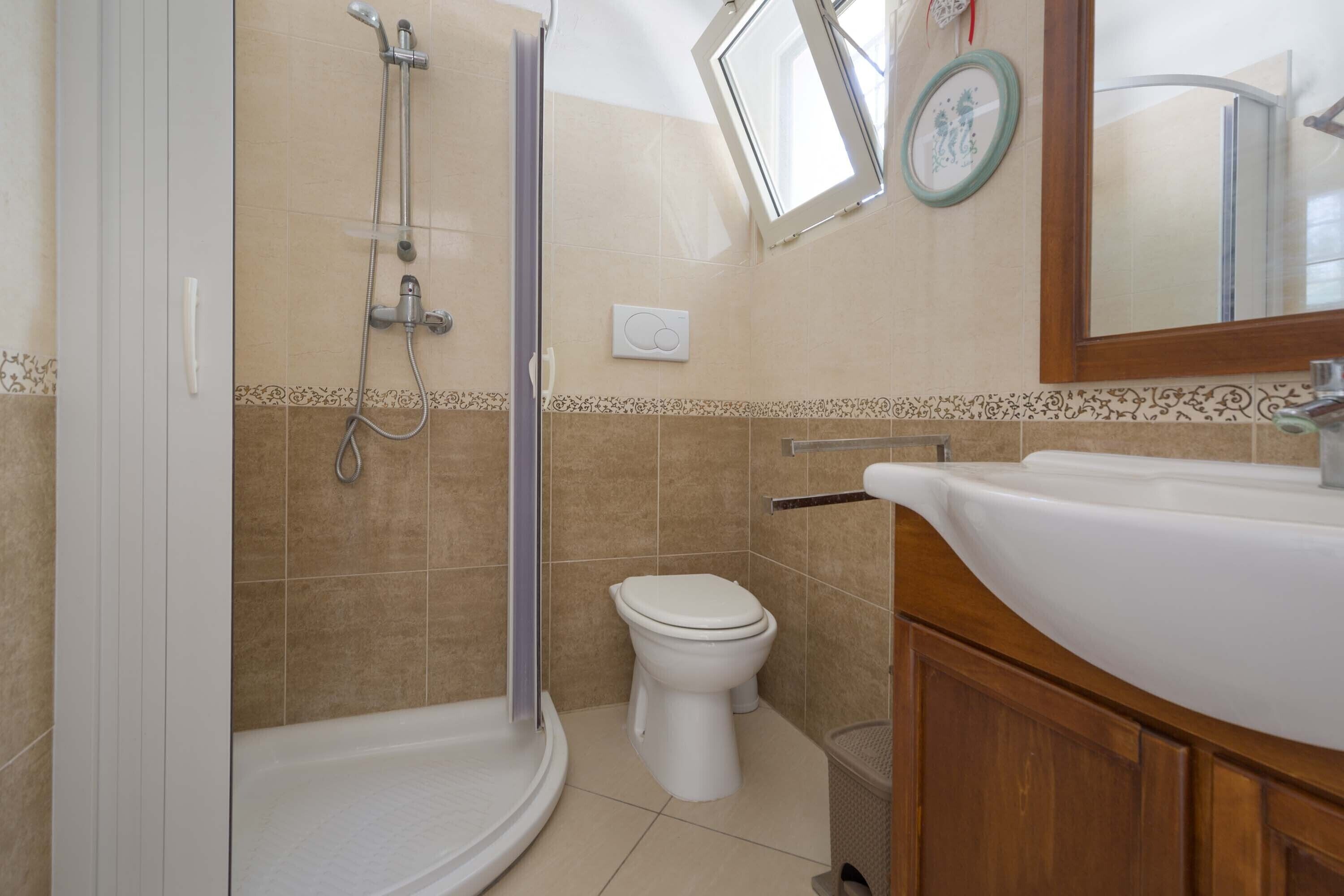 A bathroom with a shower, toilet, and sink.