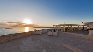 A waterfront patio with hexagonal seating areas and a covered structure. - 2251 Appartamento Sara by Barbarhouse (Gallipoli)