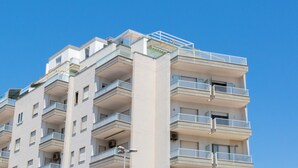 A multi-story building with balconies and a clear blue sky. - 2016 Attico Bellavista (Gallipoli)