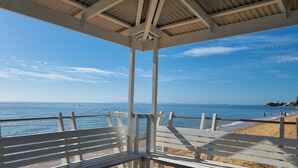 Une vue sur la plage depuis un pavillon couvert doté d’une balustrade.