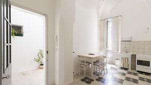 Une cuisine équipée d’une table à manger, de chaises, d’un évier et d’un four.