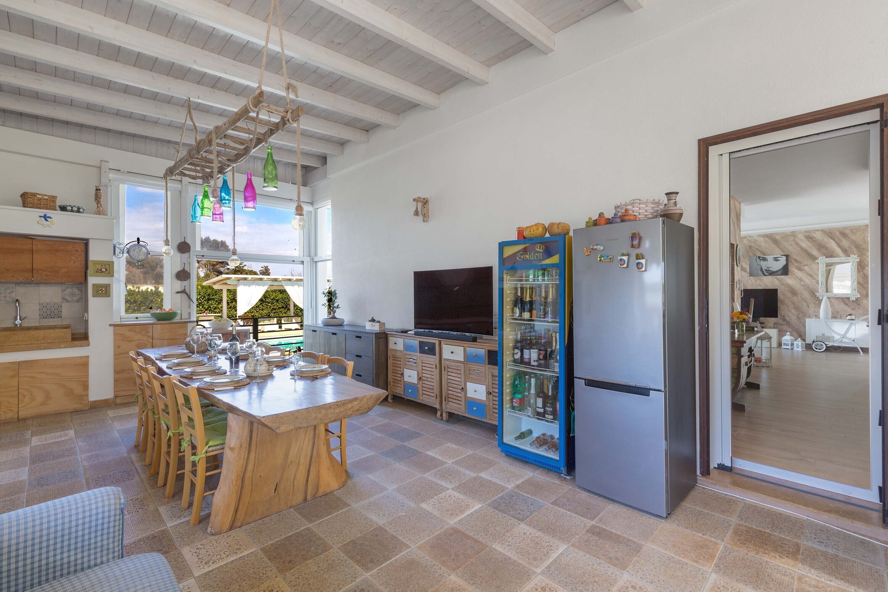 Uma cozinha espaçosa com uma ilha grande, armários de madeira e geladeira embutida.