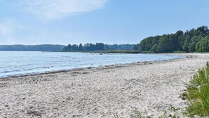 A sandy beach with a calm sea and a forested shoreline. - Stunning home in Sölvesborg with WiFi (Sölvesborg)