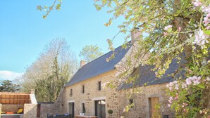 Un bâtiment en pierre doté d’un patio, d’un espace extérieur aménagé pour s’asseoir et d’un petit jardin.