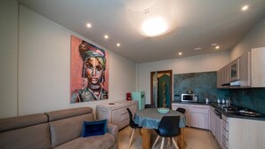 Un espacio habitable pequeño con kitchenette, comedor y sofá.