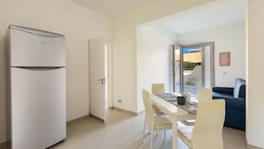 A compact living space with a kitchenette, a dining area, and a sofa. - 2103 Villetta Clara (Nardò)