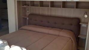 Ein Schlafzimmer mit einem großen Bett, Einbauschränken und einem Nachttisch.