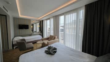 Deluxe kamer, balkon, gedeeltelijk uitzicht op zee | Luxe beddengoed, een minibar, een kluis op de kamer, een bureau