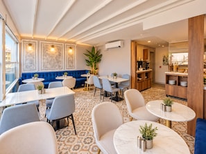 A modern dining area with round tables, blue upholstered seating, and a patterned floor. - Serai Hotel (Istanbul)