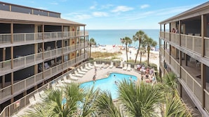Un hôtel doté d’une piscine, de plusieurs balcons et offrant une vue sur la plage.