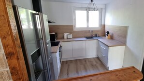 A compact kitchen with a refrigerator, microwave, toaster, and wooden countertop. - Elegant T3 near the center of Montpellier (Montpellier)