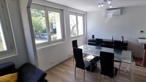 A modern kitchen with a glass dining table, black chairs, and large windows. - Elegant T3 near the center of Montpellier (Montpellier)