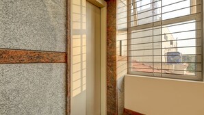 Esquina de una habitación con una ventana, una puerta y una pared con diseño de piedra.