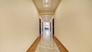 Un pasillo largo y estrecho con piso pulido e iluminación empotrada.