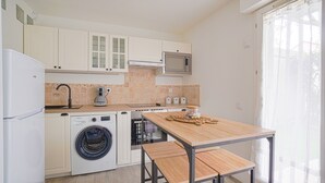 Une cuisine compacte équipée d’un lave-linge, d’un four à micro-ondes et d’une table avec un panier.