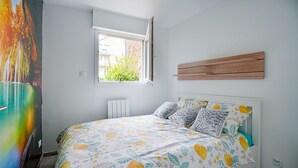 Une chambre à coucher avec un lit, une fenêtre, un radiateur et une tête de lit en bois.