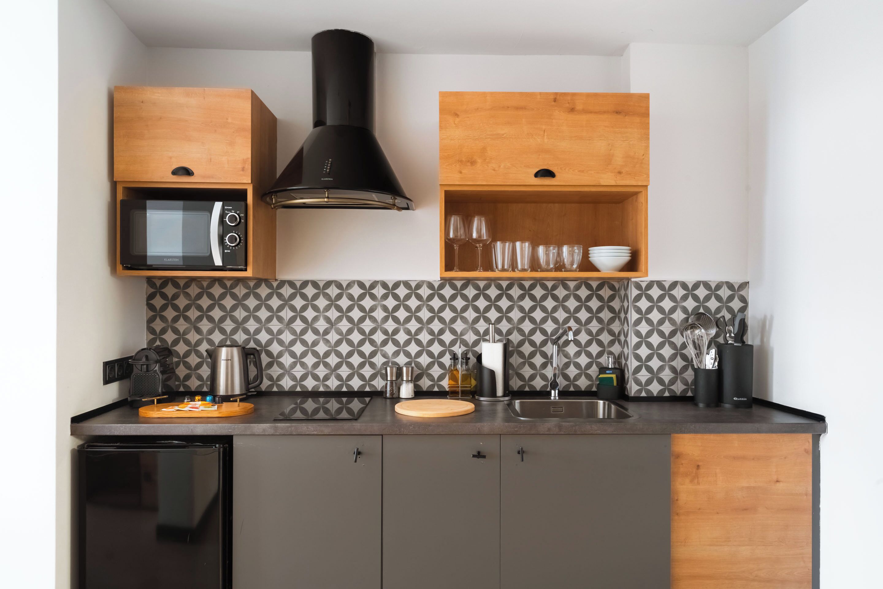 A compact kitchen with a microwave, stove, and wooden cabinets.