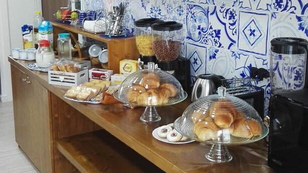Una barra de desayuno con pasteles, máquinas de café y una variedad de alimentos.