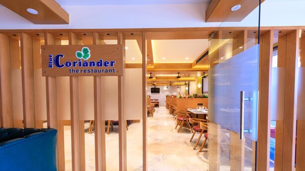 Entrada a un restaurante con un letrero que dice "Blue Coriander the restaurant".