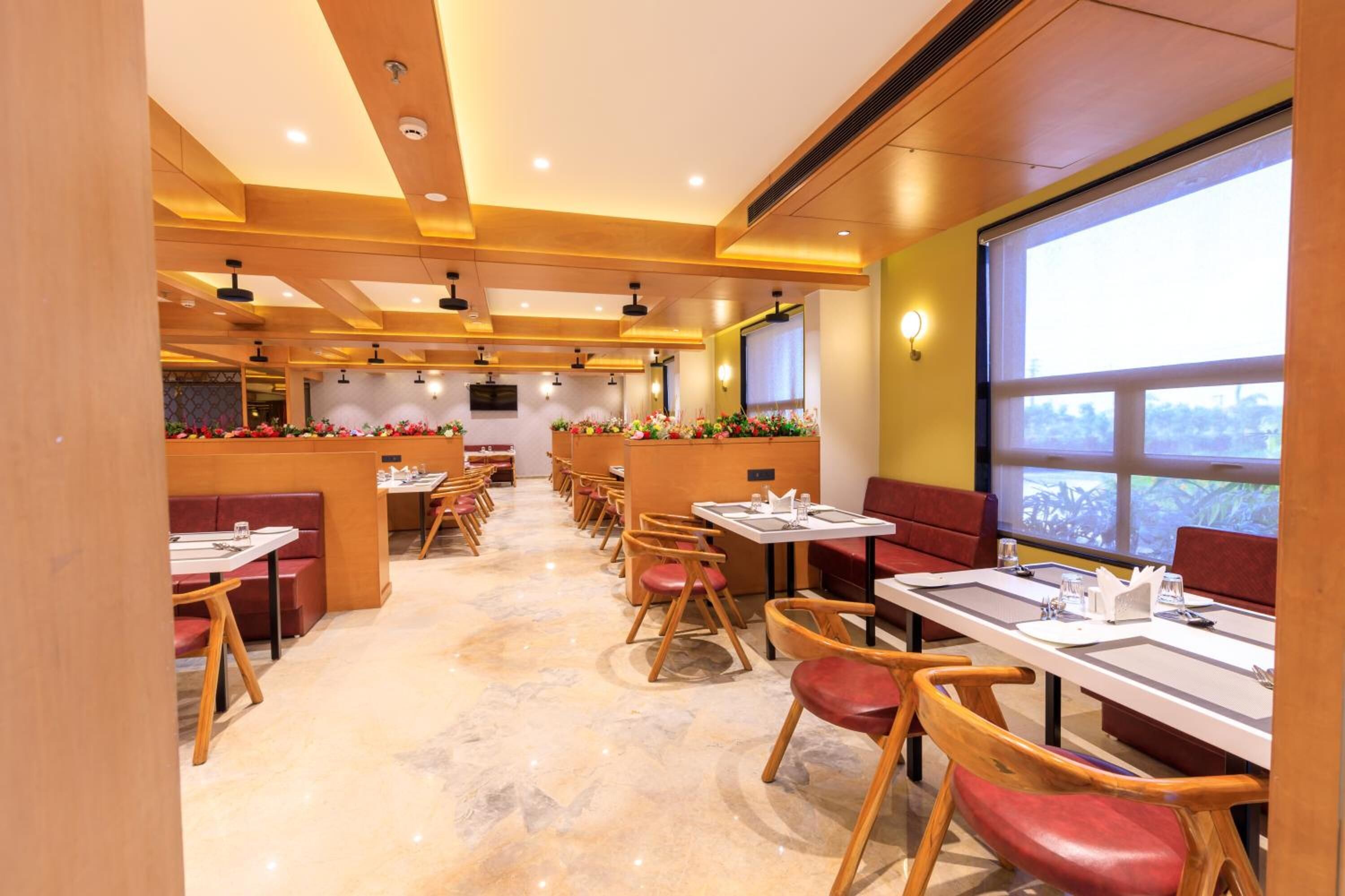 Un restaurante con una barra larga, sillas de madera y mesas.