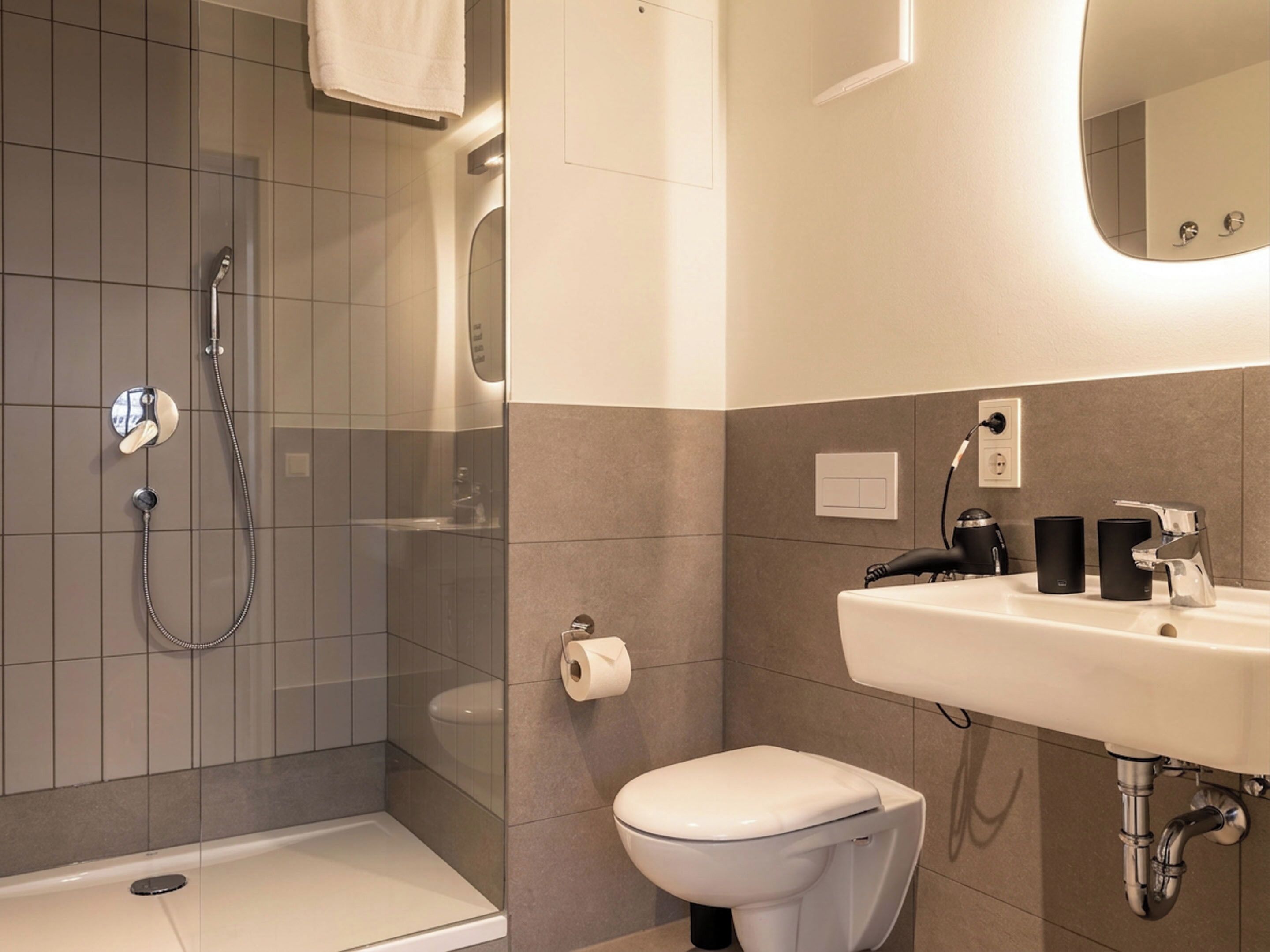 Un baño moderno con ducha, inodoro y lavabo.