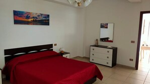 Un dormitorio con cama, mesita de noche, cómoda, un cuadro y una lámpara en el techo.