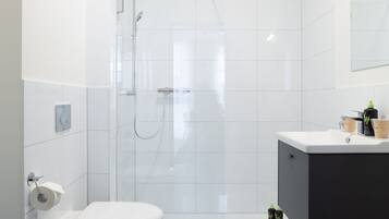 Casa de banho moderna com sanita, bidé e chuveiro.