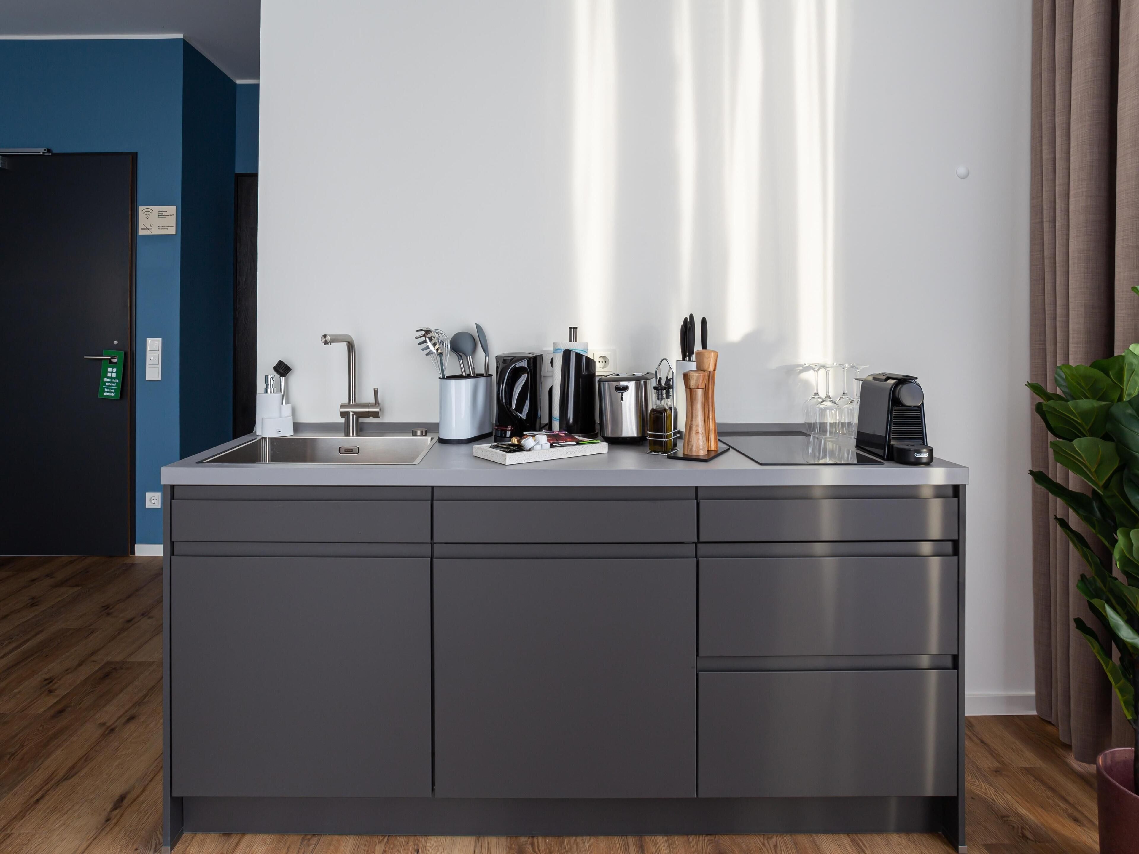 A modern kitchen with a built-in sink, stainless steel appliances, and a dark grey cabinet.